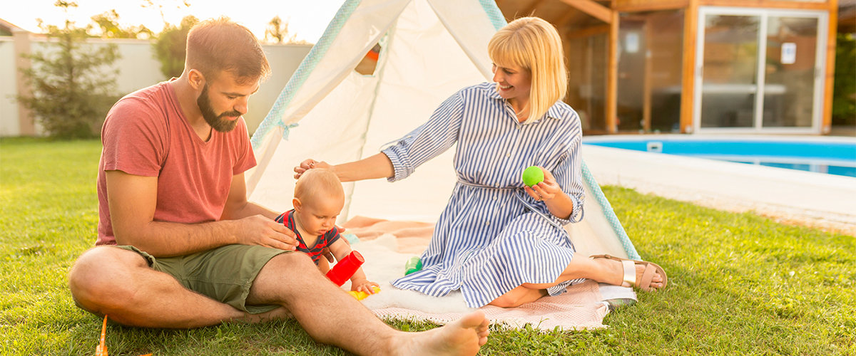 Couple with baby in a tent in their backyard